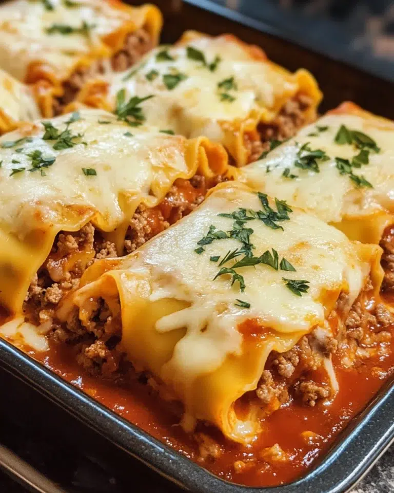 Cheesy beef lasagna rolls topped with melted mozzarella and marinara sauce.