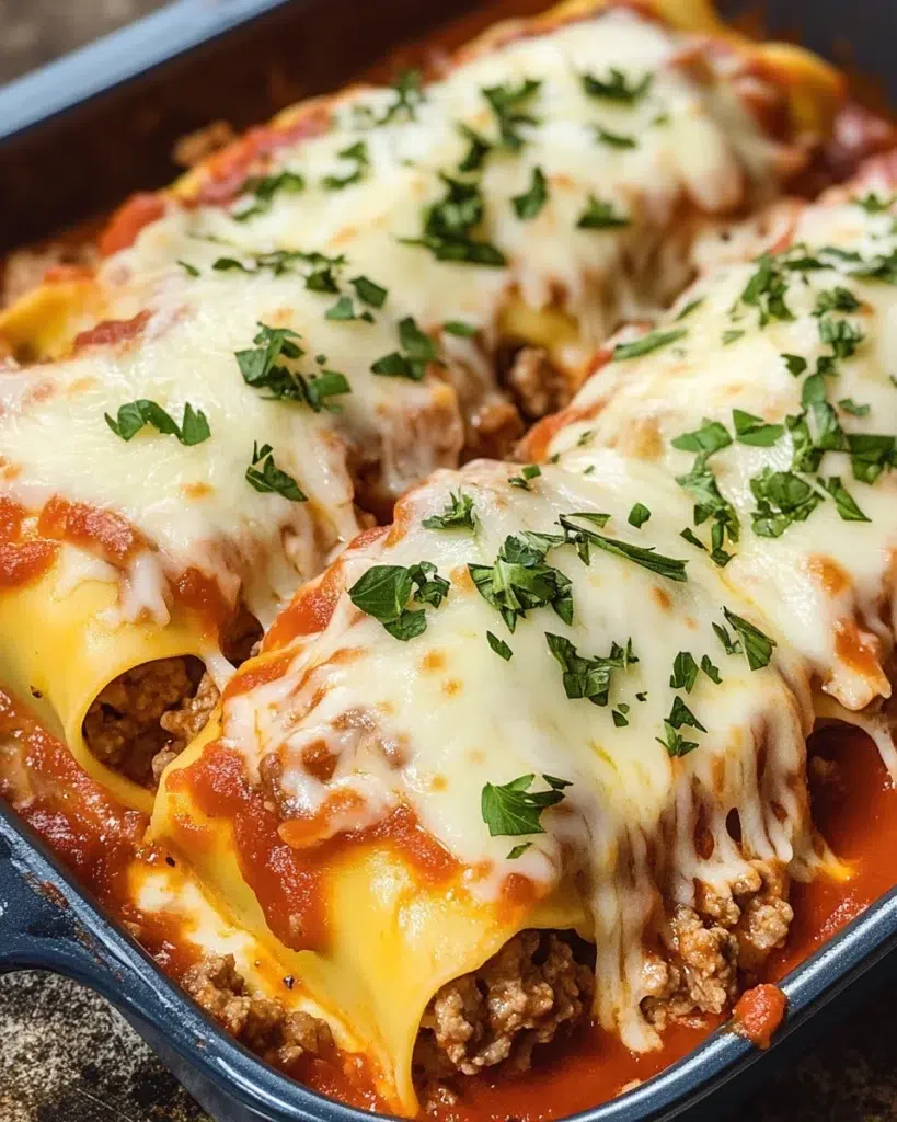 Cheesy beef lasagna rolls topped with melted mozzarella and marinara sauce.