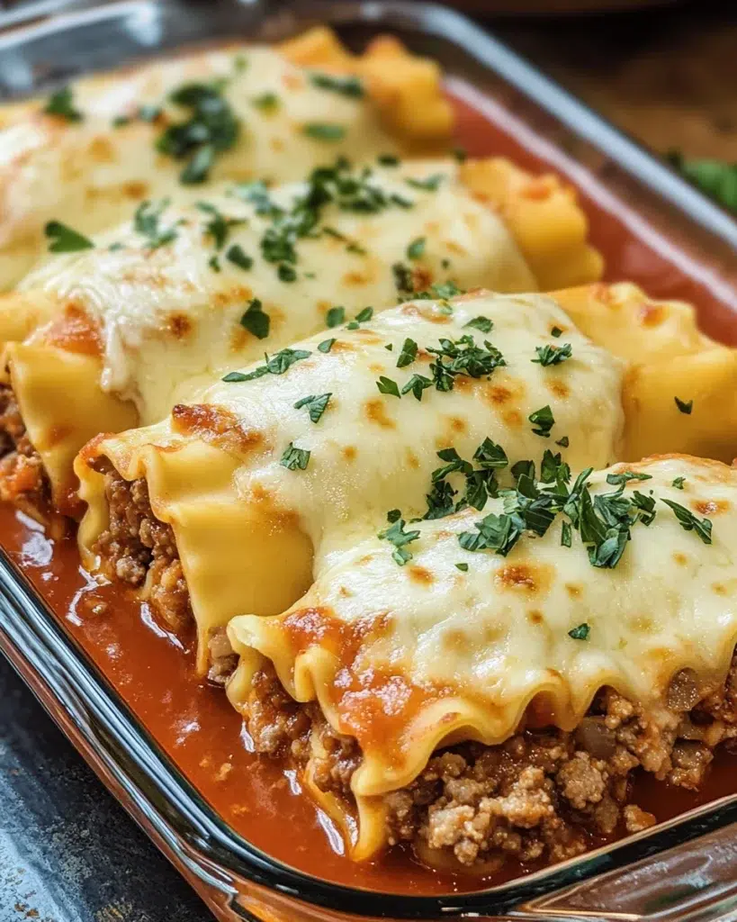 Cheesy beef lasagna rolls topped with melted mozzarella and marinara sauce.